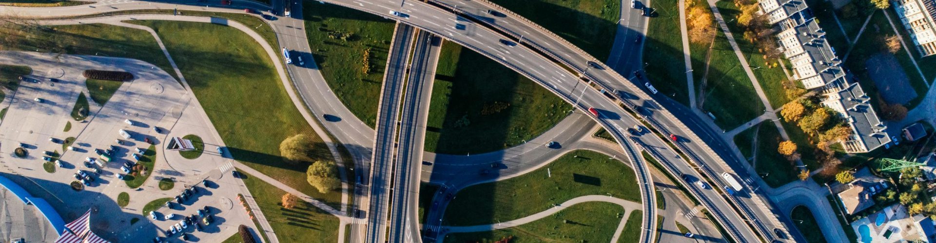 Aerial photograph of a complex highway interchange, capturing dynamic city traffic.